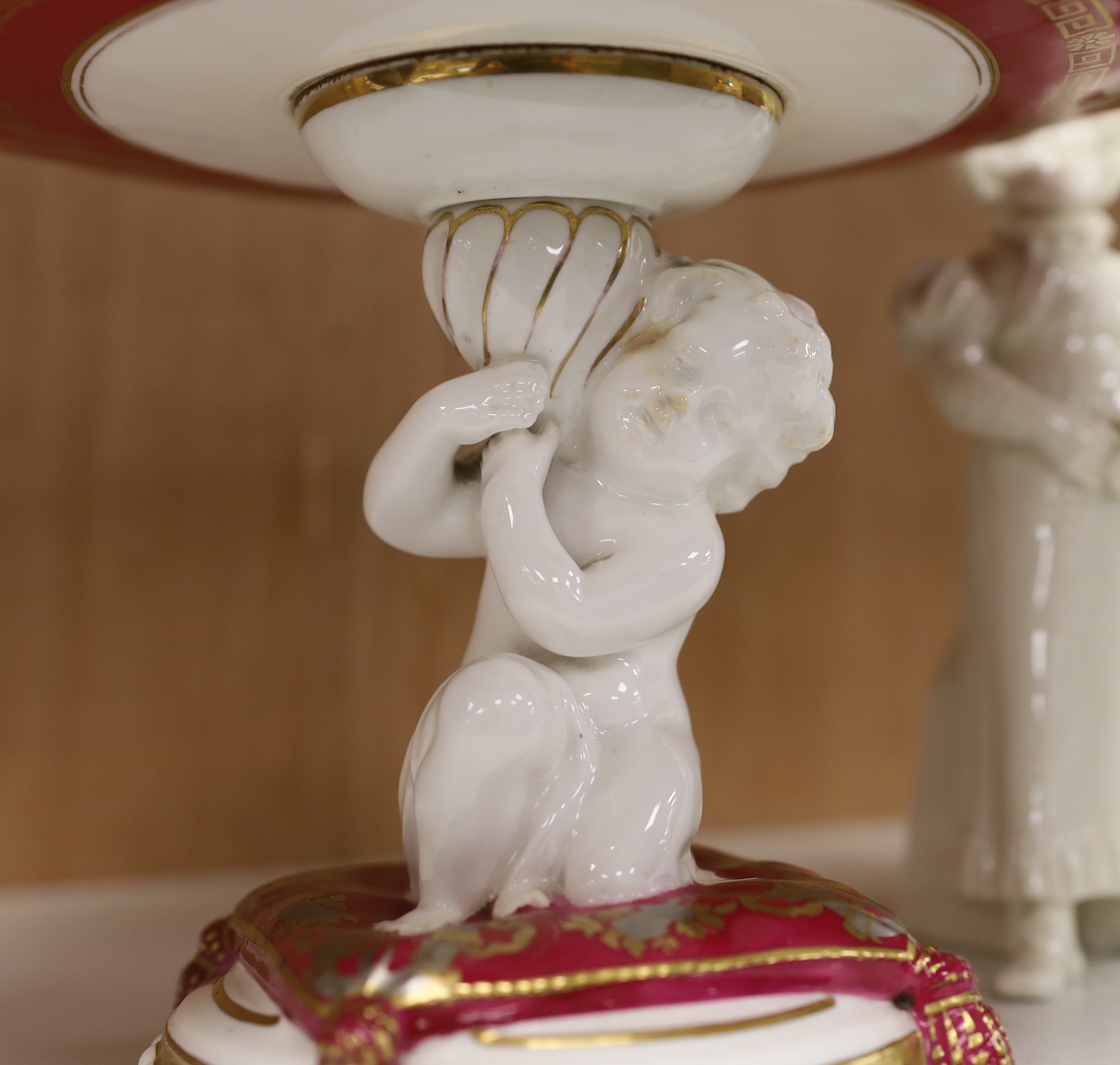 A pair of Royal Worcester Hadley type figural sugar casters, a pot pourri and a Staffordshire putti comport, the largest 23.5cm in diameter